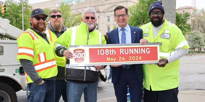 Doug Boles poses with a 108th Running of the Indianapolis 500 street sign in Indianapolis