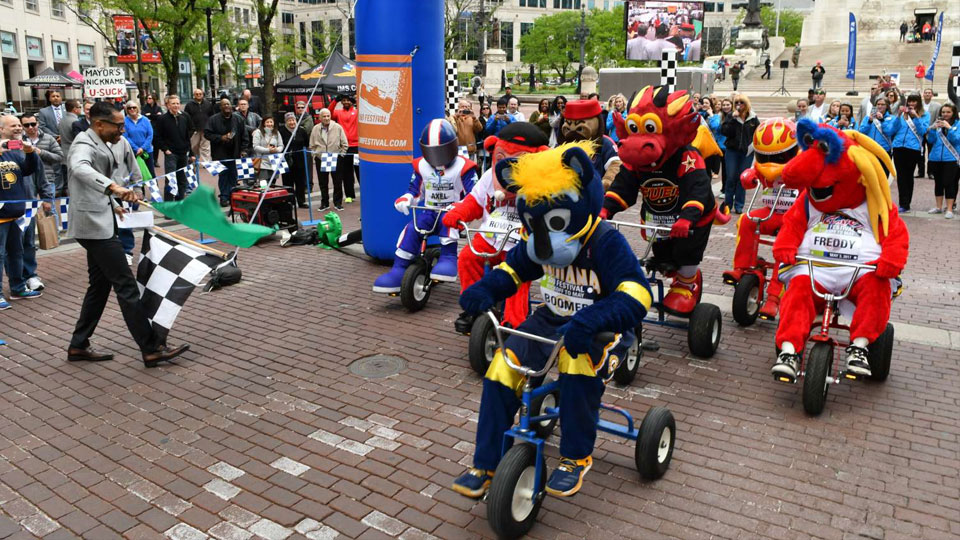 Sports mascots start a tricycle race on Monument Circle
