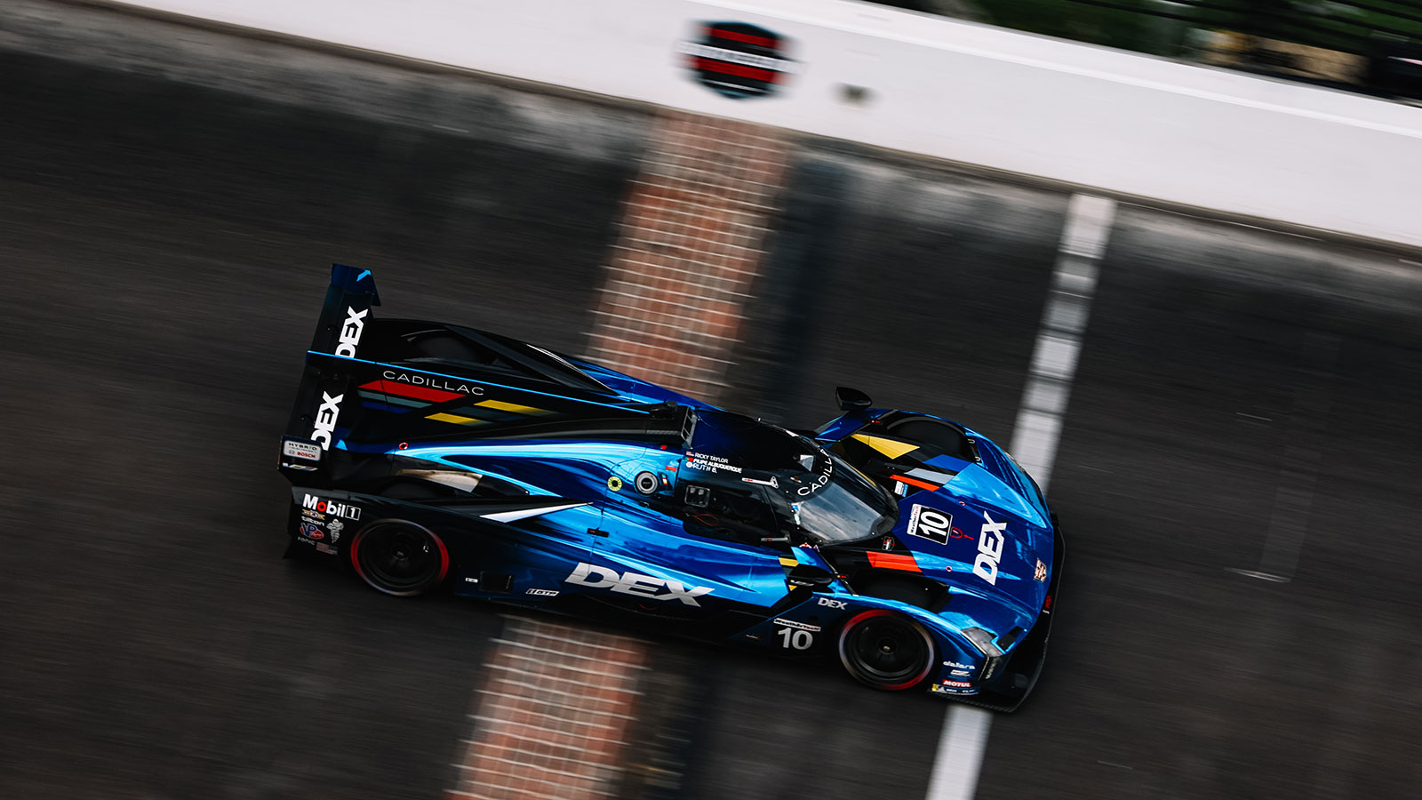 An IMSA car crosses the yard of bricks