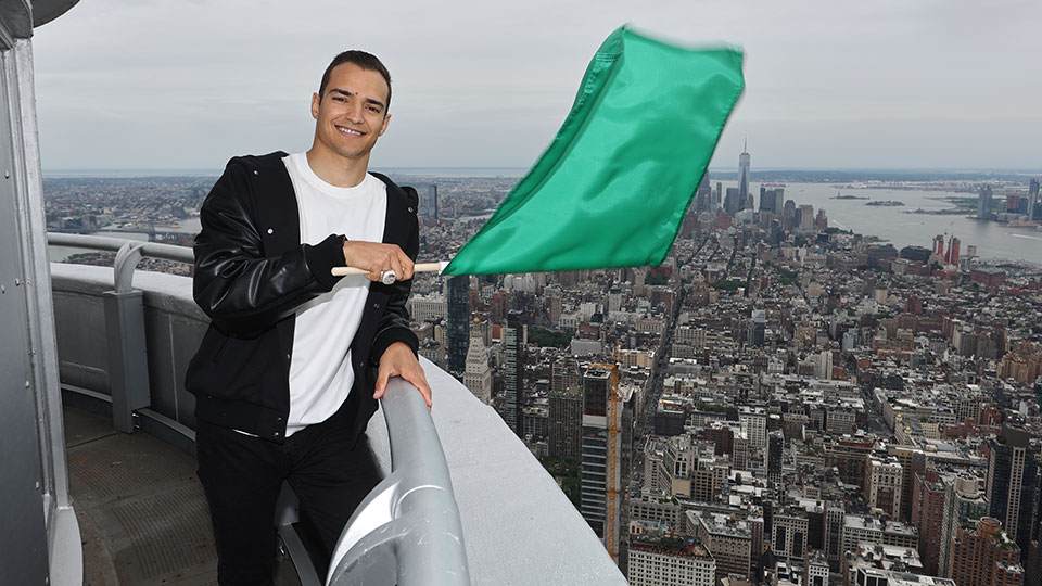 Alex Palou stands on the Empire State Building with the Green Flag