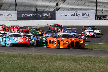 GT World Challenge cars fan out in Turn 1 of Indianapolis Motor Speedway in 2023