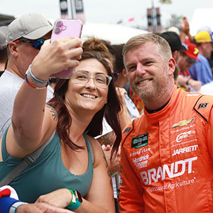 A fan poses with Justin Allgaier
