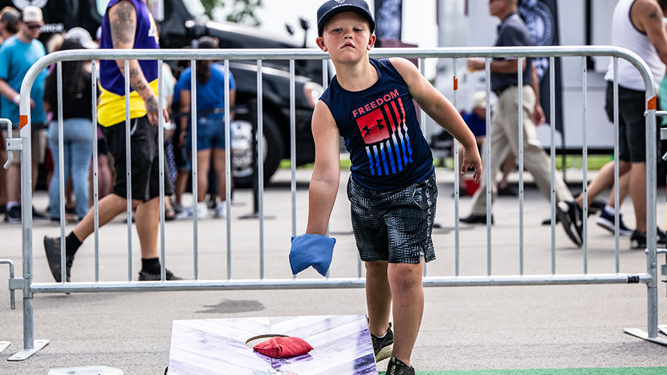 A fan plays cornhole.