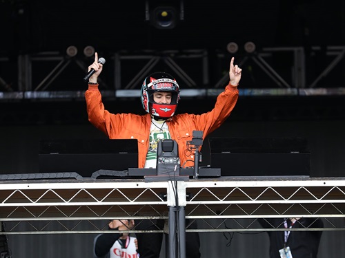 A snake pit musical acts wears and INDYCAR helmet