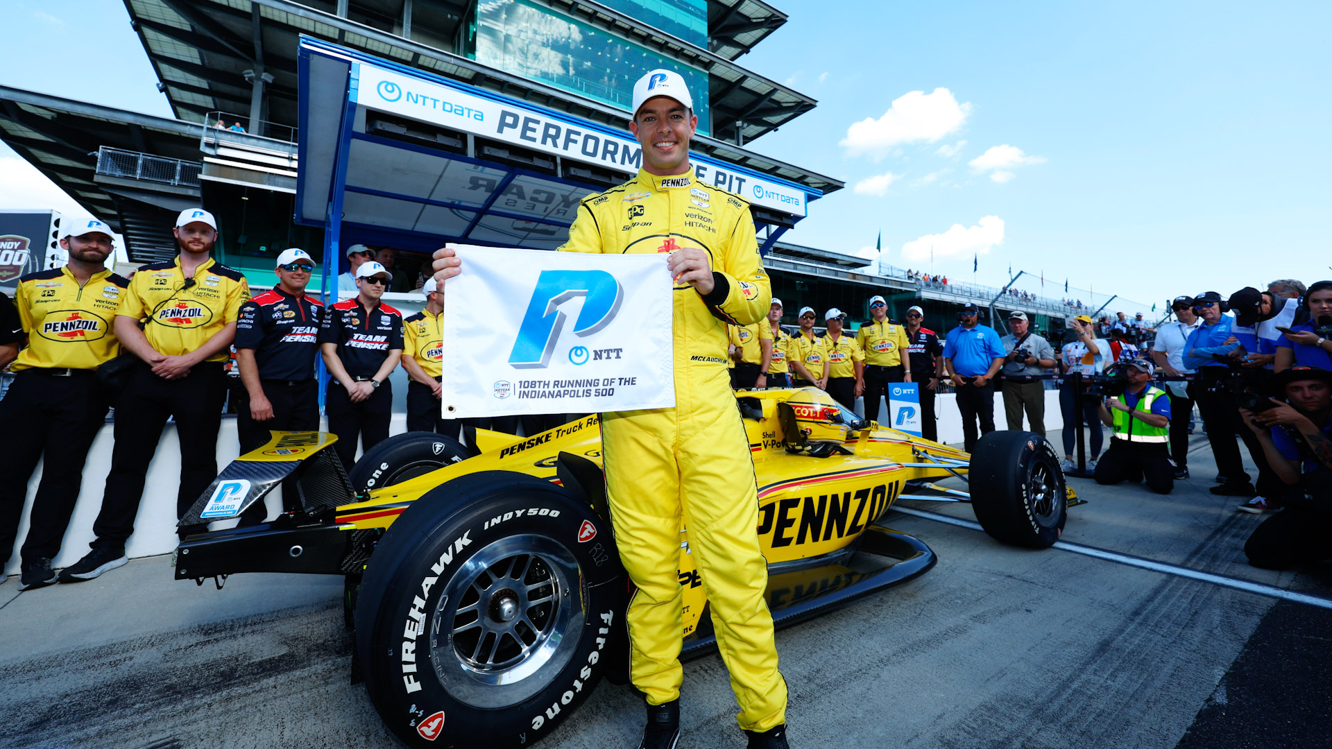 Scott McLaughlin shows the NTT pole Award in front of the #3 car on pit road at Indianapolis Motor Speedway 