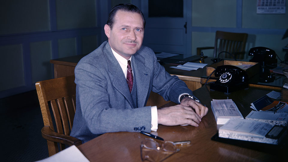Wilbur Shaw sits at his desk