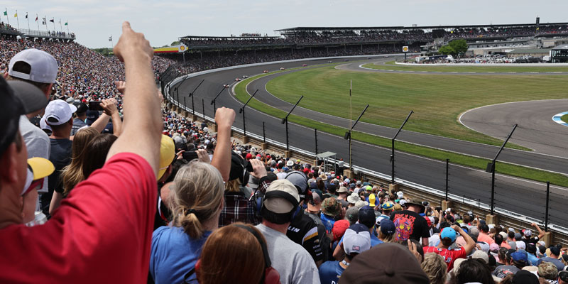 Thousands of fans in turn 1 of Indianapolis Motor Speedway react to the start of the 2023 Indianapolis 500