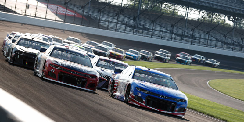 The NASCAR field comes through turn 1 at Indianapolis Motor Speedway in 2020