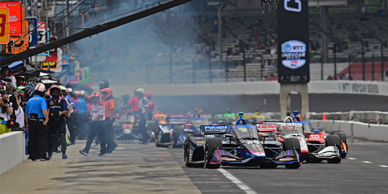 Multiple cars leave their pit boxes on pit road at Indianapolis Motor Speedway
