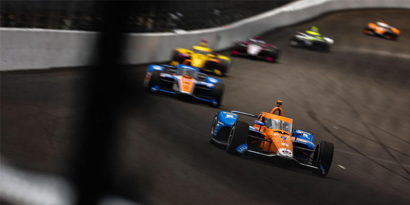 Scott Dixon leads a long line of cars through a turn during Indianapolis 500 practice
