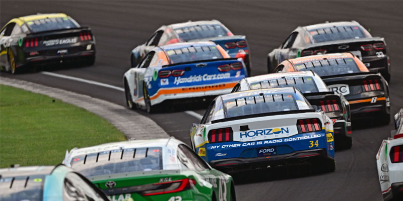 Multiple cars running through the turn in 2024